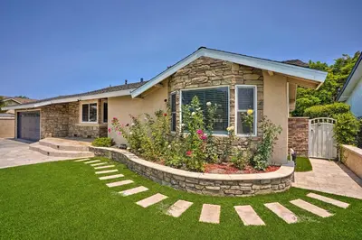 a house with a garden in front of it at Quiet Anaheim Home with Pool, 5 Mi to Disney! in Anaheim