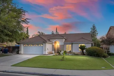 a house with a garage in a residential neighborhood at Revitalizing 3 Bedroom Home With Pool, Pet-Friendly, Wi-fi in Bakersfield