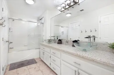 a bathroom with two sinks and a tub and a shower at Revitalizing 3 Bedroom Home With Pool, Pet-Friendly, Wi-fi in Bakersfield