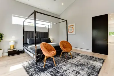 a bedroom with a bed with two chairs and a rug at Posh Luxury Modern Home with Pool Spa and Rooftop Deck in Encino
