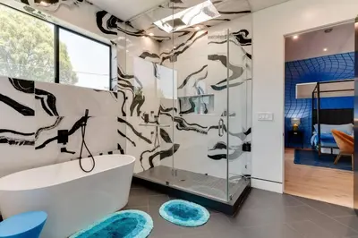 a bathroom with a tub and a glass shower stall at Posh Luxury Modern Home with Pool Spa and Rooftop Deck in Encino
