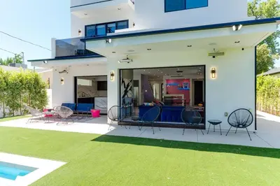 a white house with chairs and a yard at Posh Luxury Modern Home with Pool Spa and Rooftop Deck in Encino