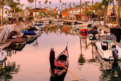 a man in a gondola in a harbor with boats at Beautiful 2 Story Right by the Water, Ocean View in Long Beach
