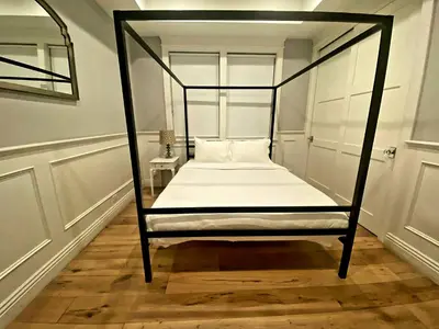 a bedroom with a four poster bed with white sheets at Beautiful 2 Story Right by the Water, Ocean View in Long Beach