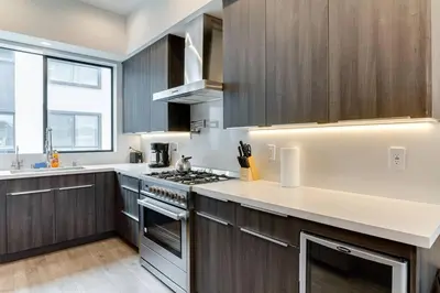 a kitchen with wooden cabinets and a stove top oven at Luxury Modern 4 bedroom 3 Bath Home With Rooftop Deck #3 in Los Angeles