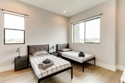 a bedroom with two beds and two windows at Luxury Modern 4 bedroom 3 Bath Home With Rooftop Deck #3 in Los Angeles