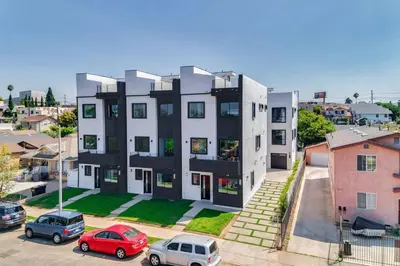 an apartment building with cars parked in a parking lot at 2 Luxury Modern 8 Bedroom Home with Rooftop Decks in Los Angeles