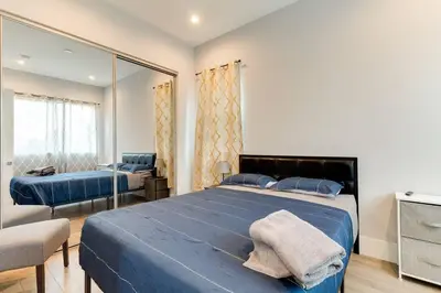 a bedroom with a large blue bed and a mirror at 2 Luxury Modern 8 Bedroom Home with Rooftop Decks in Los Angeles