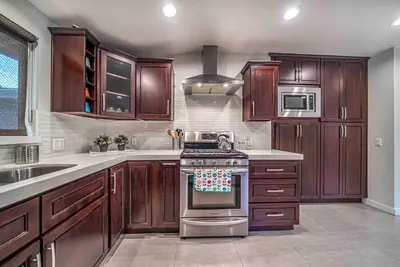 a kitchen with wooden cabinets and a stove top oven at Luxury house pool & Spa 10 mins from Hollywood & Universal Studios in Los Angeles
