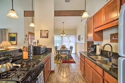 a kitchen with wooden cabinets and a stove top oven at 3 Mi to Skiing Big Bear Cabin with Deck in Big Bear City