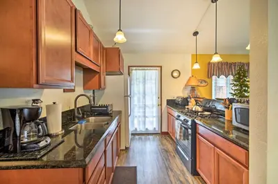 a kitchen with wooden cabinets and a counter top at 3 Mi to Skiing Big Bear Cabin with Deck in Big Bear City