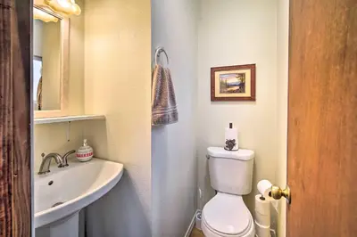 a bathroom with a white toilet and a sink at 3 Mi to Skiing Big Bear Cabin with Deck in Big Bear City