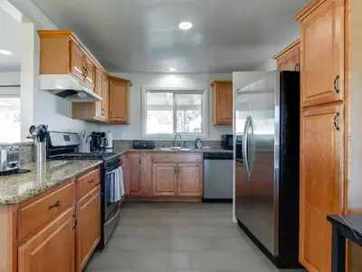 a kitchen with wooden cabinets and a stainless steel refrigerator at 5 Bedroom Charmer in Granada Hills in Granada Hills