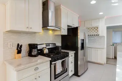 a kitchen with white cabinets and a stove top oven at Valley Modern Glam Charmer in Reseda