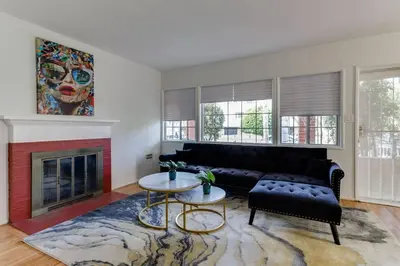 a living room with a black couch and a fireplace at New 4 bedroom Modern Villa in Mar Vista in Los Angeles