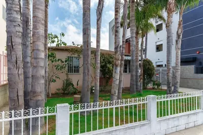 a white fence with palm trees in front of a building at New 4 bedroom Modern Villa in Mar Vista in Los Angeles
