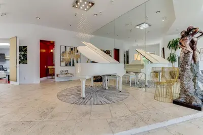 a living room with a white piano and other furniture at Beverly Hills City View Mansion in Los Angeles