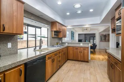 a large kitchen with wooden cabinets and a sink at 4 Bedroom house large pool & spa in prime location in Los Angeles