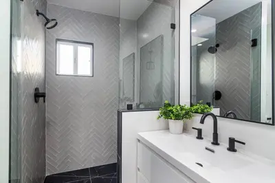 a bathroom with a sink and a shower with a mirror at 4 Bedroom house large pool & spa in prime location in Los Angeles