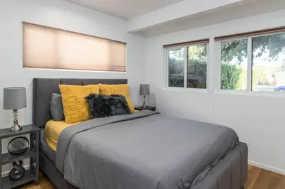 a bedroom with a bed and two windows at 4 Bedroom house large pool & spa in prime location in Los Angeles