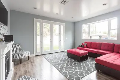 a living room with a red couch and a fireplace at Lake Balboa Modern 4 Bedroom 3 Bath Glam Charmer in Raymer