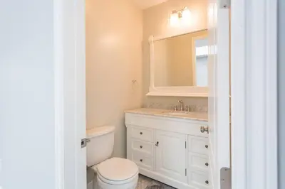 a bathroom with a toilet and a sink and a mirror at Lake Balboa Modern 4 Bedroom 3 Bath Glam Charmer in Raymer
