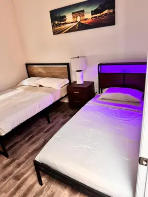 two beds in a room with purple lighting at Lake Balboa Modern 4 Bedroom 3 Bath Glam Charmer in Raymer