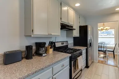 a kitchen with white cabinets and a stove top oven at 4 bedroom house with a pool in Reseda