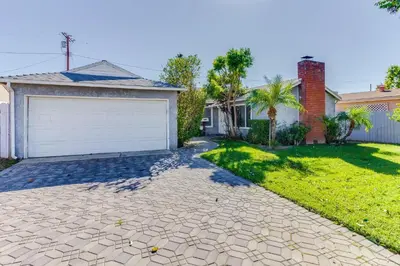 a house with a driveway and a garage at 4 bedroom house with a pool in Reseda