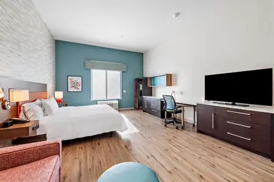 a hotel room with a bed and a flat screen tv at Home2 Suites By Hilton San Bernardino in San Bernardino