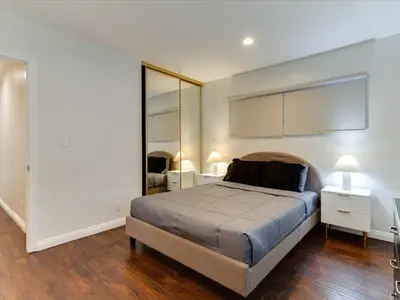 a bedroom with a bed and a large mirror at Woodland Hills Zen Modern in Woodland Hills