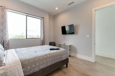a bedroom with a bed and a flat screen tv at Luxury Modern 4 Bedroom 3 Bathroom Home with Rooftop Deck #1 in Los Angeles
