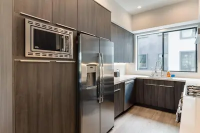 a kitchen with a stainless steel refrigerator and a microwave at Luxury Modern 4 Bedroom 3 Bathroom Home with Rooftop Deck #1 in Los Angeles