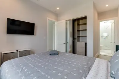 a bedroom with a bed and a flat screen tv at Luxury Modern 4 Bedroom 3 Bathroom Home with Rooftop Deck #2 in Los Angeles