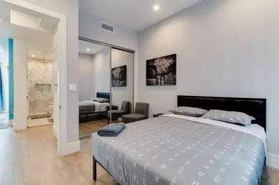 a bedroom with a large bed and a living room at Luxury Modern 4 Bedroom 3 Bathroom Home with Rooftop Deck #2 in Los Angeles