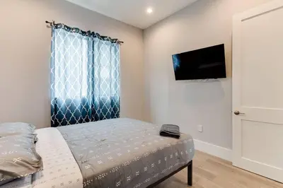 a bedroom with a bed and a flat screen tv at Luxury Modern 4 Bedroom 3 Bathroom Home with Rooftop Deck #2 in Los Angeles