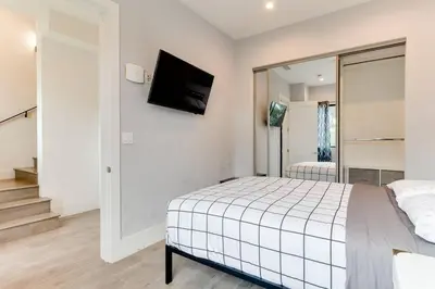 a bedroom with a bed and a tv on the wall at Luxury Modern 4 Bedroom 3 Bathroom Home with Rooftop Deck #2 in Los Angeles