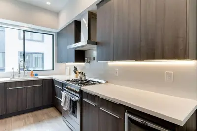 a kitchen with brown cabinets and a white counter top at Luxury Modern 4 Bedroom 3 Bathroom Home with Rooftop Deck #2 in Los Angeles