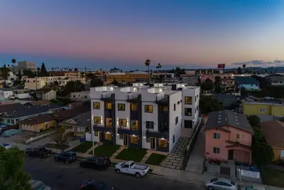 a large white building in a city at dusk at Luxury Modern 4 Bedroom 3 Bathroom Home with Rooftop Deck #2 in Los Angeles