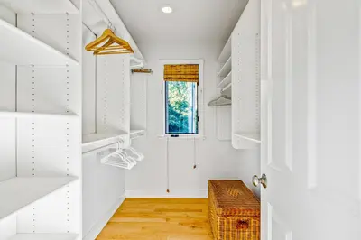 a white walk in closet with white shelves at Golden Getaway in Summerland