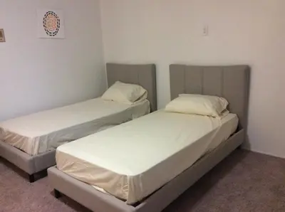 two beds in a room with white sheets at 5 bedroom 3 bath home near universal in Sherman Oaks