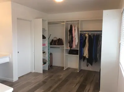 a walk in closet with white cabinets and wood floors at 5 bedroom 3 bath home near universal in Sherman Oaks