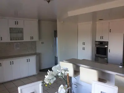 a kitchen with white cabinets and a table and chairs at 5 bedroom 3 bath home near universal in Sherman Oaks