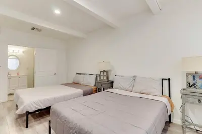 two beds in a room with white walls at Large 5 bedroom charmer wIth pool in Los Angeles