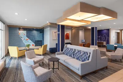a waiting room with a couch and chairs at Holiday Inn Express & Suites Hawaiian Gardens by IHG in Hawaiian Gardens