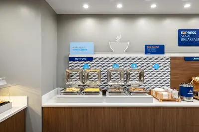 a bakery with a counter with trays of food at Holiday Inn Express & Suites Hawaiian Gardens by IHG in Hawaiian Gardens