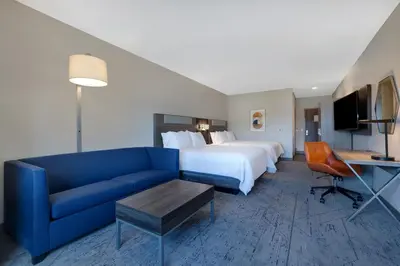 a hotel room with a bed and a blue couch at Holiday Inn Express & Suites Ontario - Chino Hills by IHG in Chino Hills