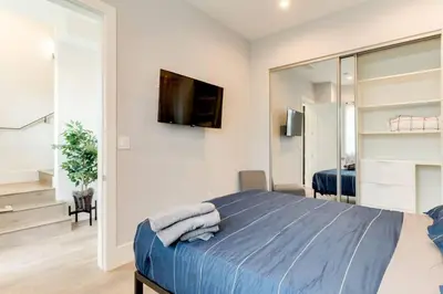 a bedroom with a bed and a tv on a wall at 3 Luxury Modern Homes 12 bedrooms & Rooftop Decks in Los Angeles