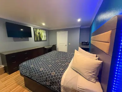 a bedroom with a bed with a blue wall at BELL RESORT MOTEL in Bell