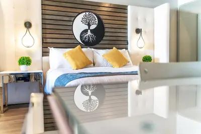 a bedroom with a bed with a wooden headboard at Aspire Inn Studios & Spas in Bellflower